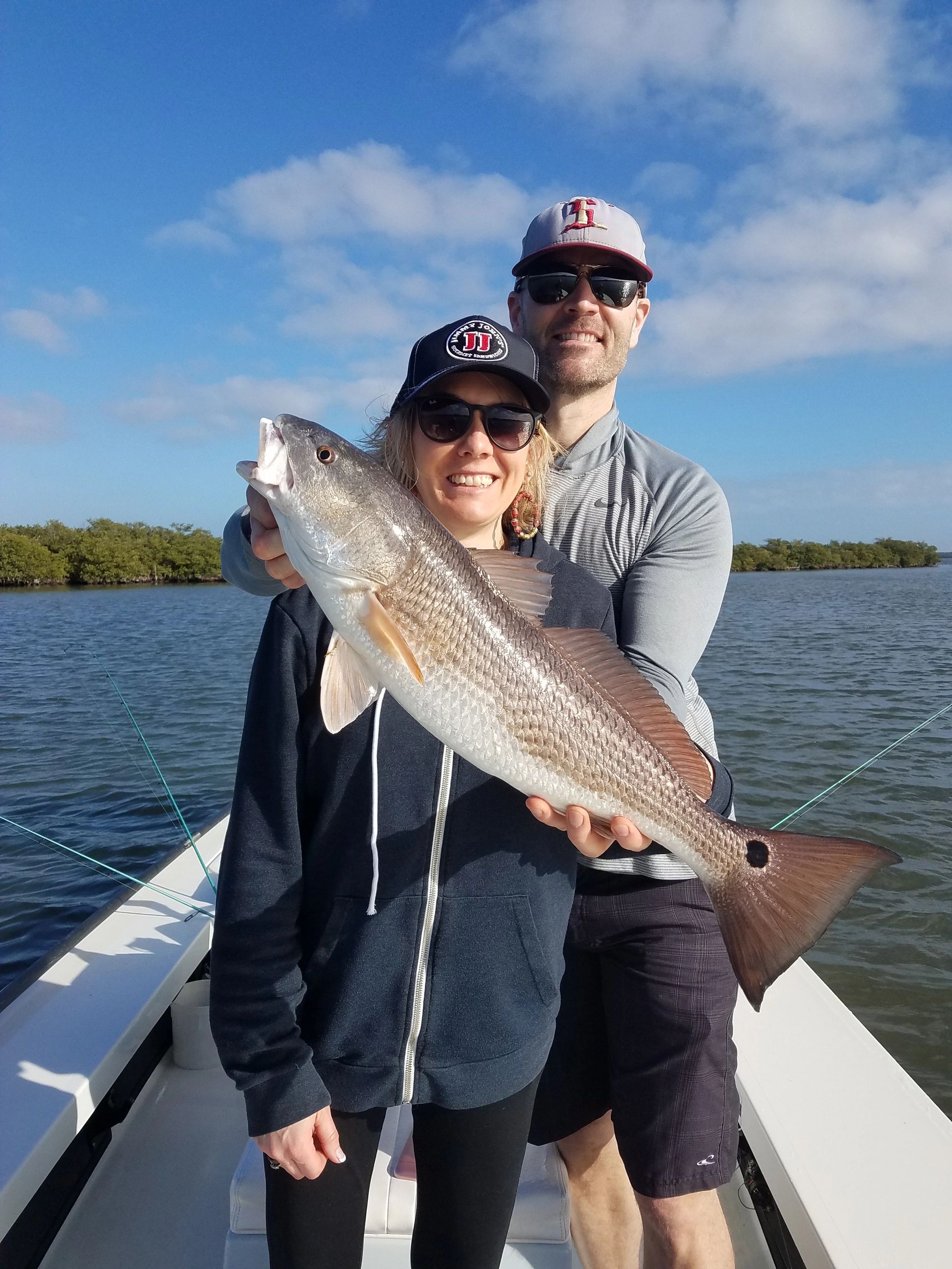 Some happy clients holding one of many nice redfish caught while doing an inshore fishing charter