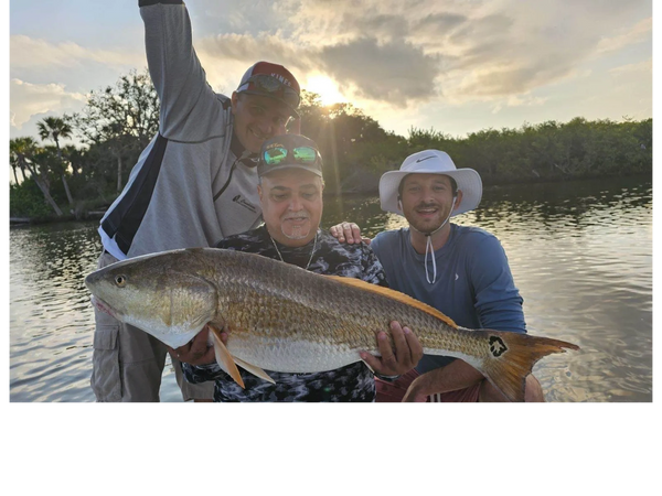 Client with redfish caught while Inshore fishing charter here in New Smyrna Beach