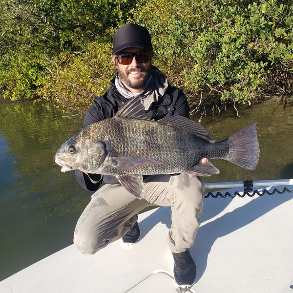 Client holding a drum fish caught inshore fishing in New Smyrna Beach during winter